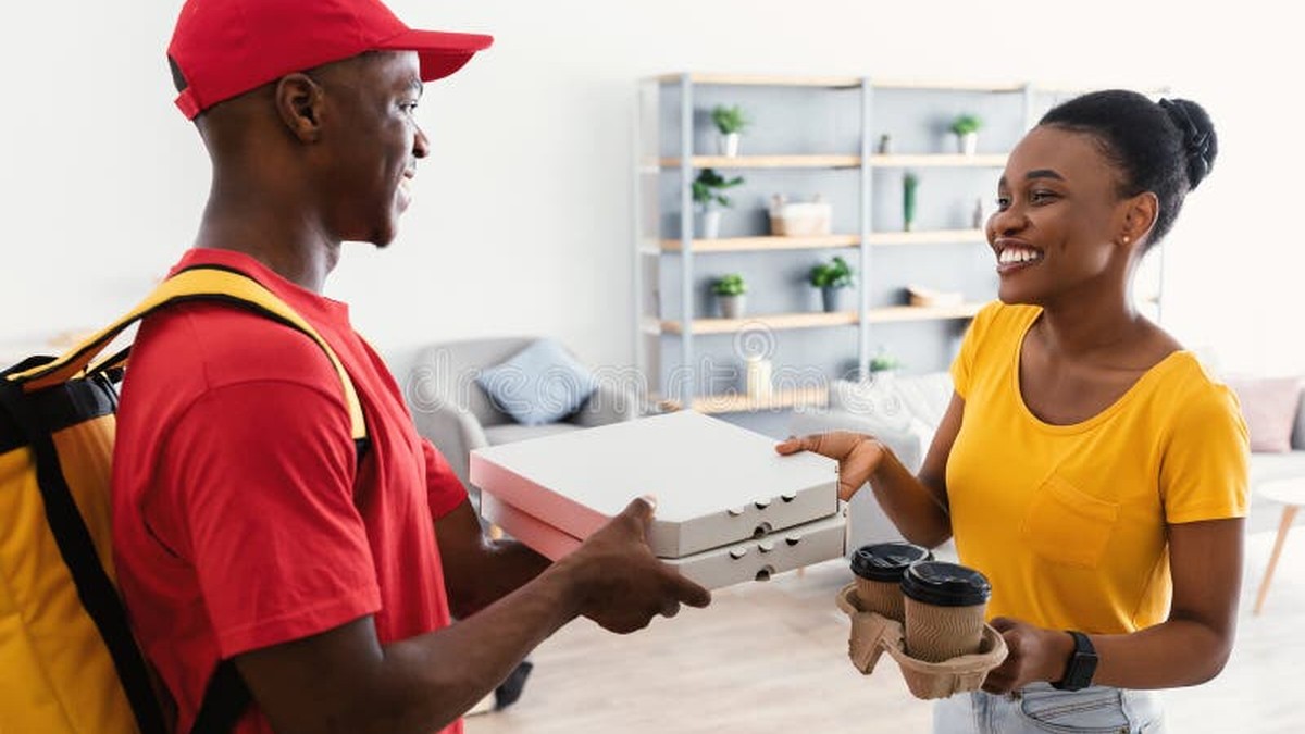 Happy delivery moment — courier handing a package to a smiling recipient