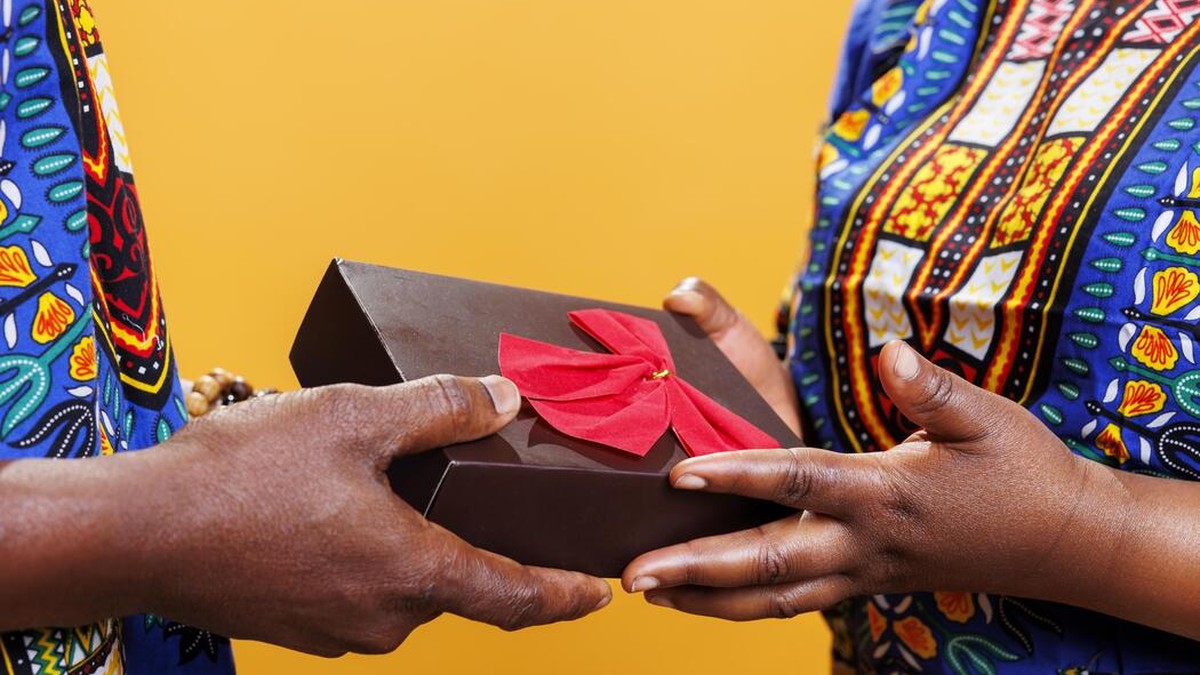 South African hands exchanging a wrapped parcel at a taxi rank